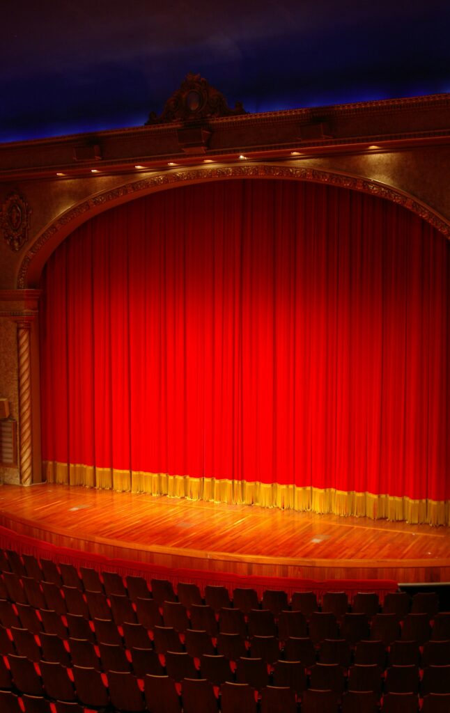 An empty stage closed by a red curtain.